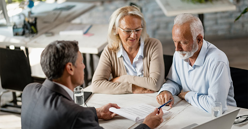 elderly couple sitting down with an estate planning lawyer